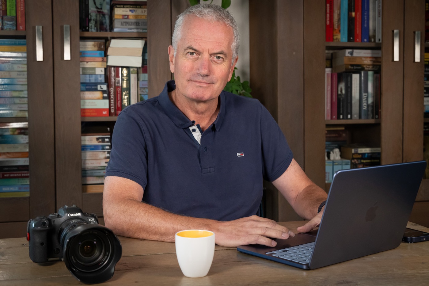 Jeroen Vlug aan tafel met zijn camera en laptop